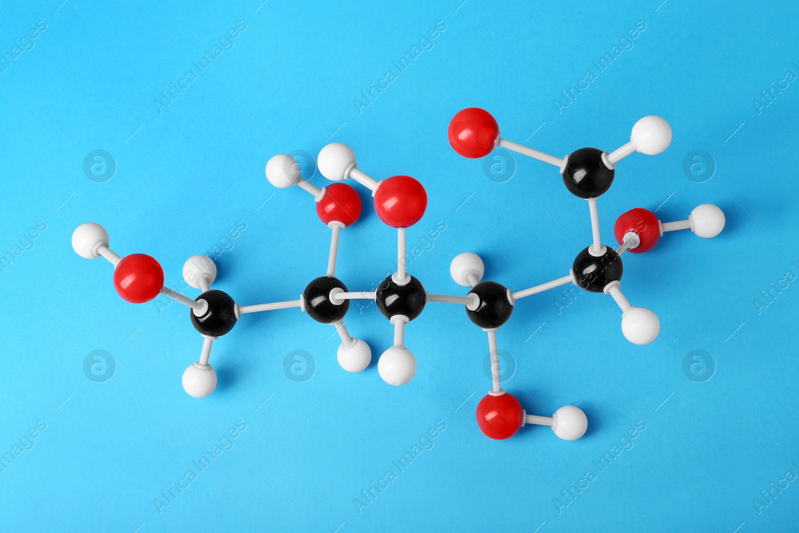Photo of Molecule of glucose on light blue background, above view. Chemical model