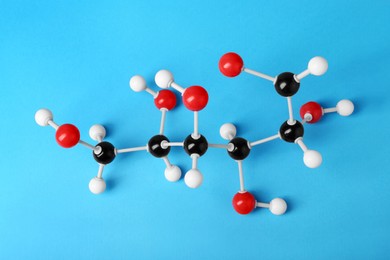 Molecule of glucose on light blue background, above view. Chemical model