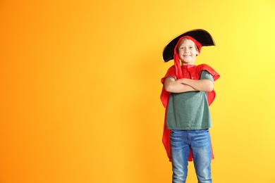 Photo of Adorable little child playing pirate on color background. Indoor recreation