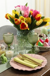 Photo of Easter celebration. Festive table setting with beautiful flowers and painted eggs