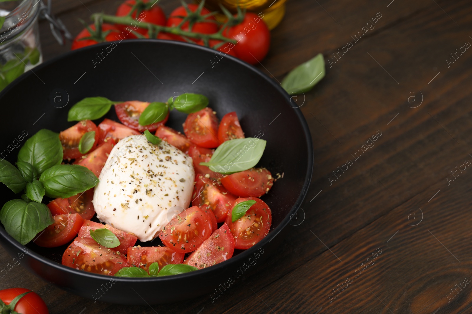 Photo of Tasty salad Caprese with mozarella, tomatoes and basil on wooden table. Space for text