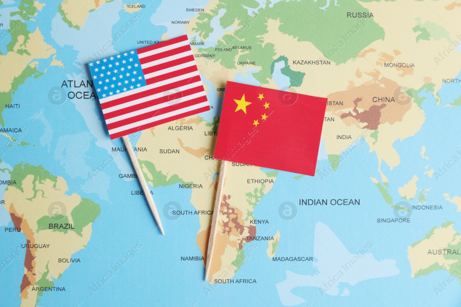 Photo of American and Chinese flags on world map, top view. Trade war concept