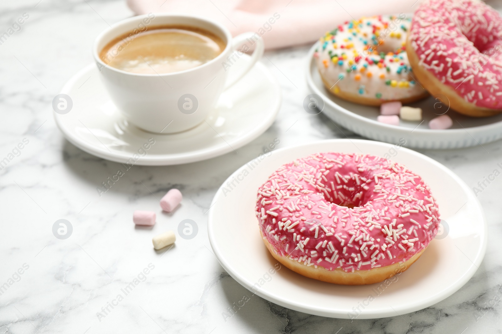 Photo of Yummy donut with sprinkles and coffee on white marble table