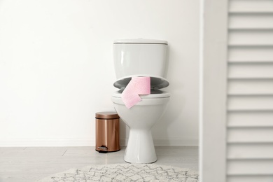 Photo of Toilet bowl with paper roll in bathroom