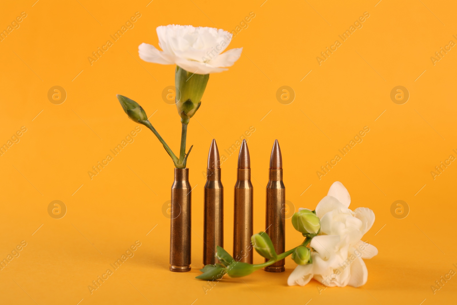 Photo of Bullets and beautiful flowers on yellow background