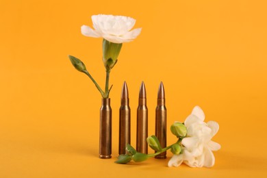 Photo of Bullets and beautiful flowers on yellow background