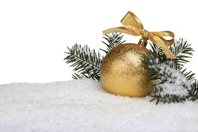 Beautiful golden Christmas ball with bow and fir tree branches on snow against white background