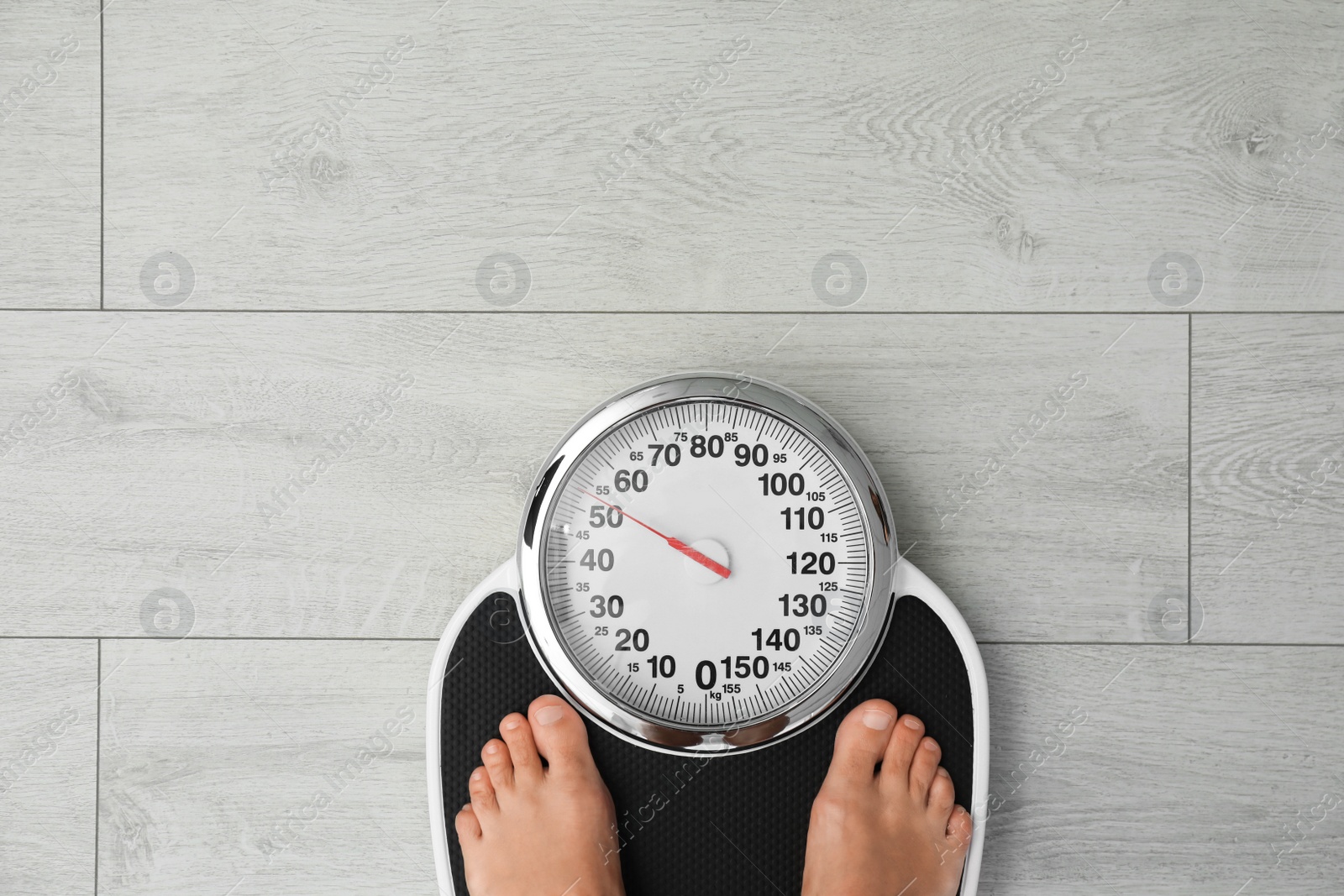 Photo of Woman standing on scales indoors, top view with space for text. Overweight problem