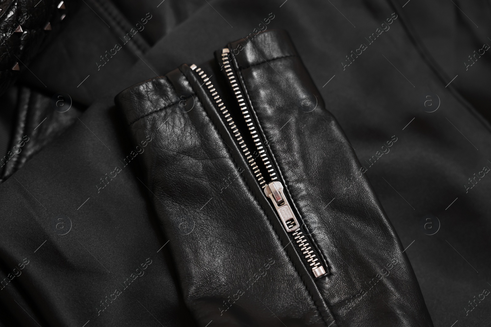 Photo of Texture of black leather jacket with zipper as background, top view