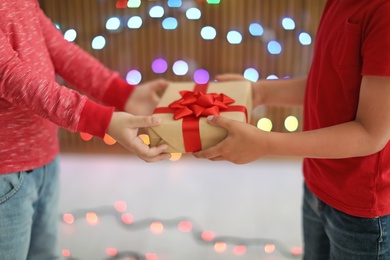 Photo of Cute little children with Christmas gift indoors