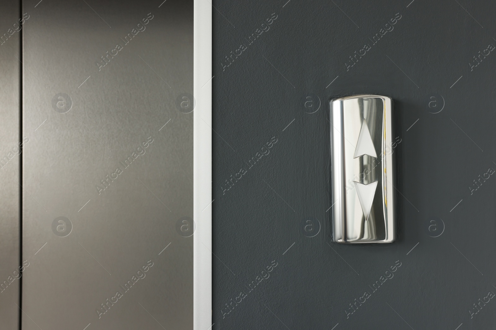 Photo of Elevator call buttons on grey wall, closeup