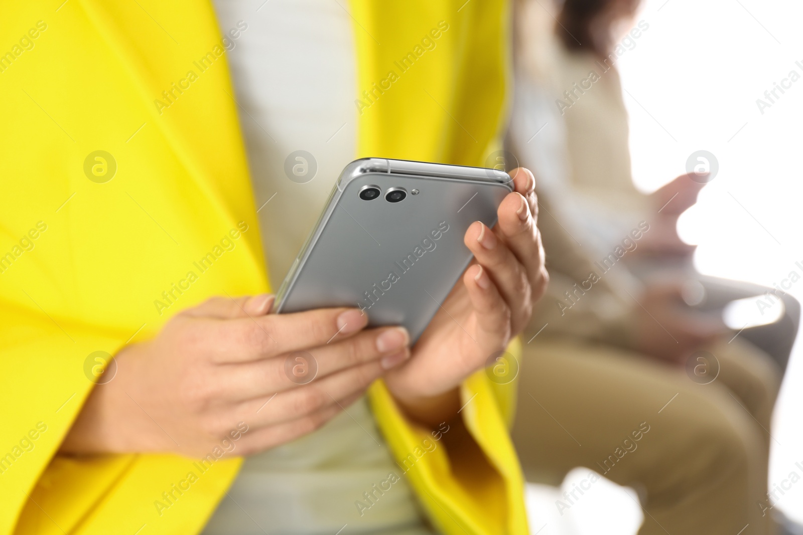 Photo of Young woman using modern smartphone indoors, closeup