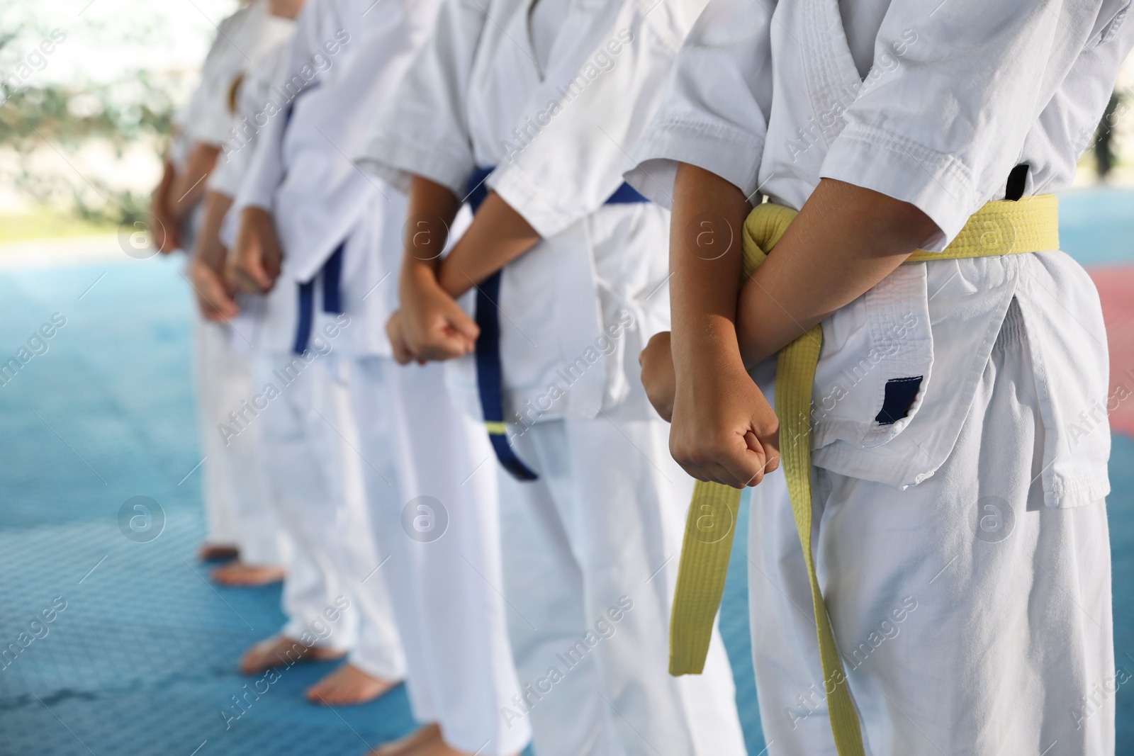 Photo of Children in kimono during karate practice on tatami, closeup