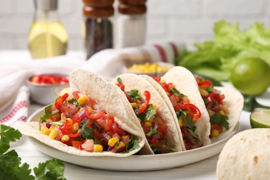 Photo of Tasty tacos with vegetables on white wooden table, closeup