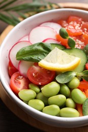 Photo of Closeup view of poke bowl with salmon, edamame beans and vegetables