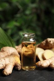Photo of Ginger essential oil in bottle on dark table