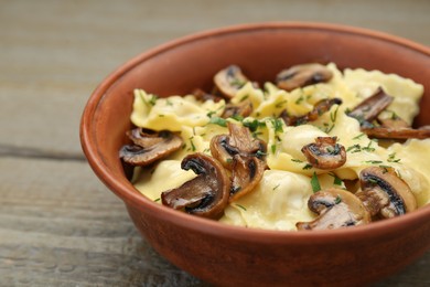 Photo of Delicious ravioli with mushrooms on wooden table, closeup