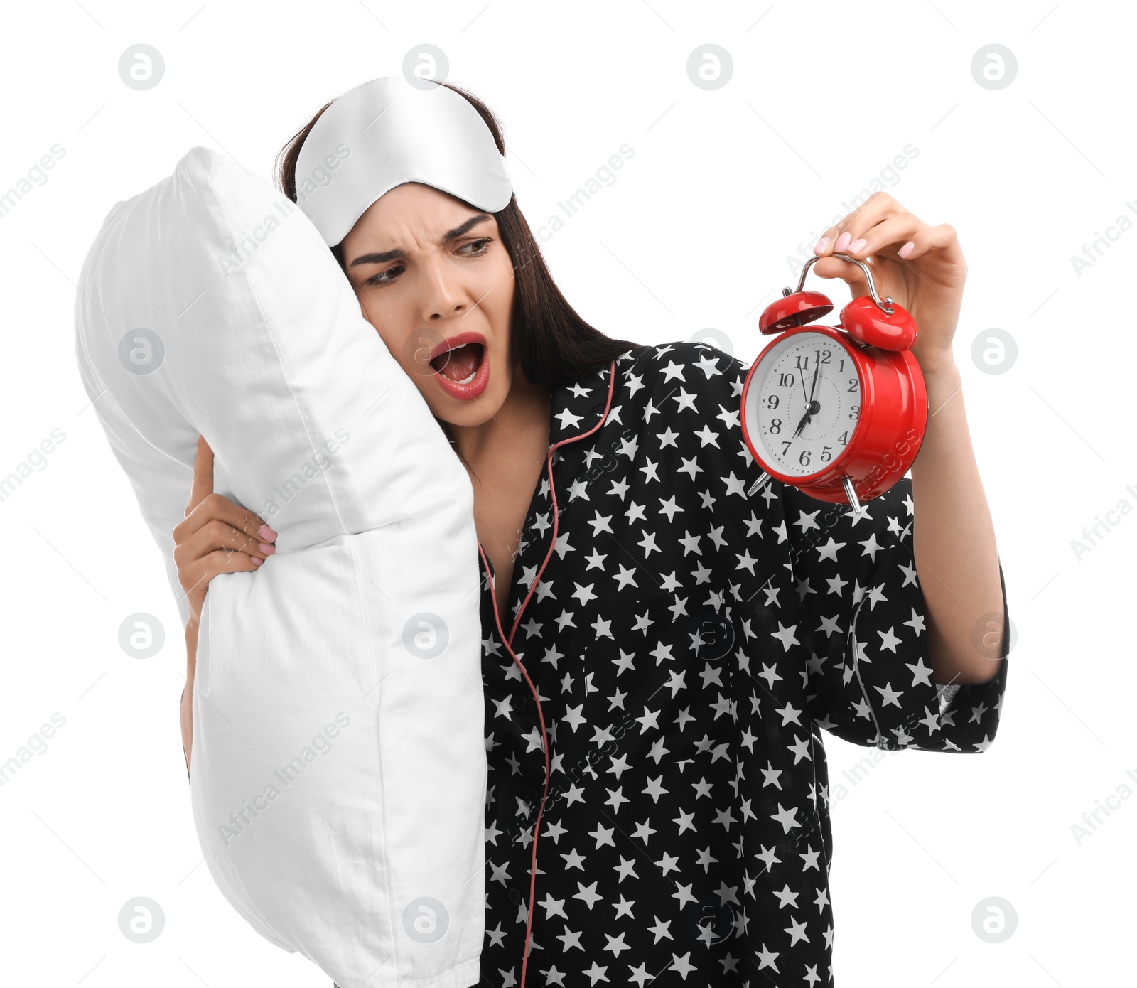 Photo of Emotional overslept woman with alarm clock and pillow on white background. Being late concept
