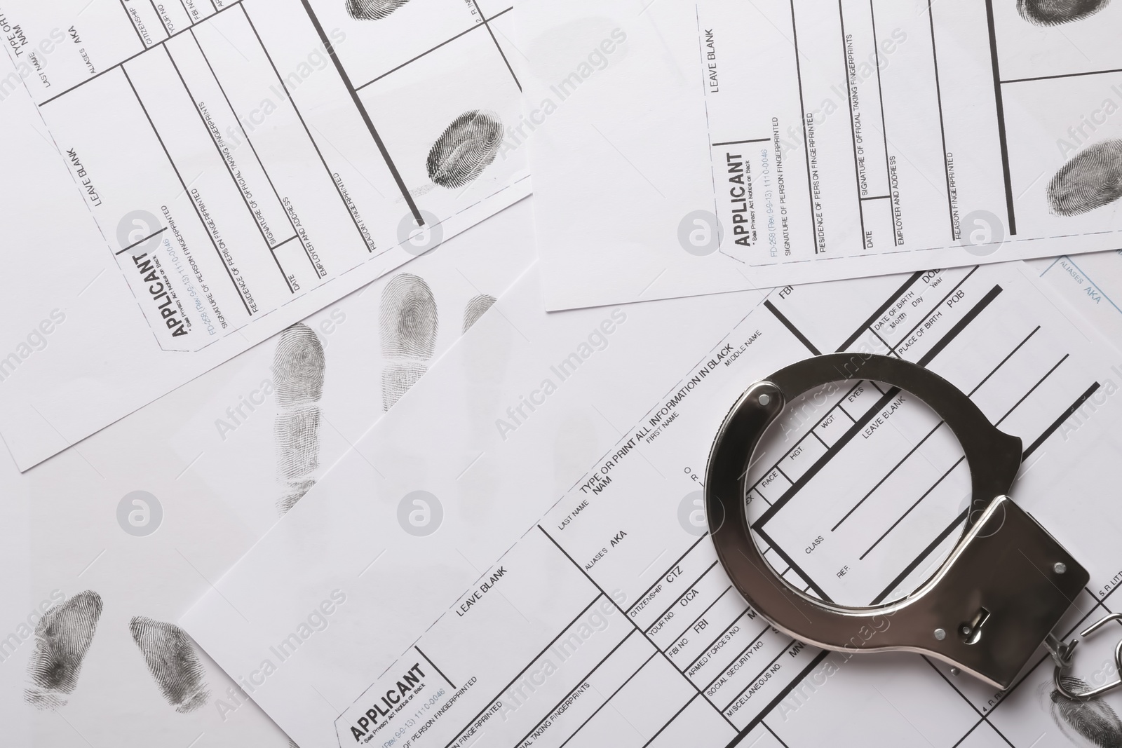 Photo of Handcuffs and fingerprint record sheets, top view. Criminal investigation