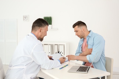Photo of Male doctor working with patient in clinic. Cardiology consultation