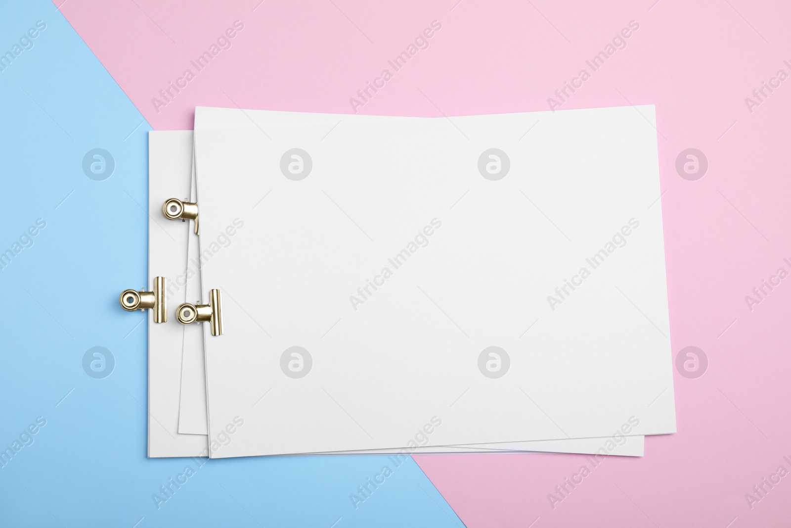 Photo of Sheets of paper with clips on color background, top view