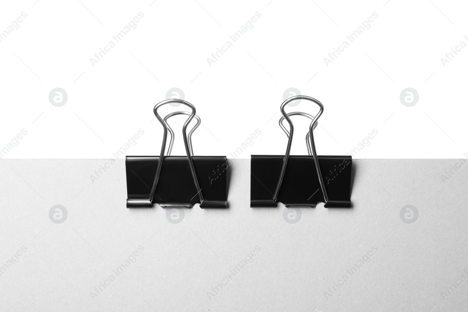 Photo of Paper with black binder clips isolated on white