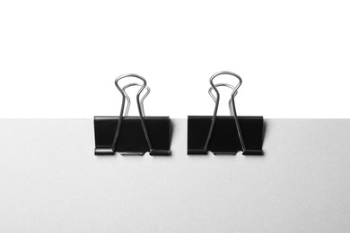 Photo of Paper with black binder clips isolated on white