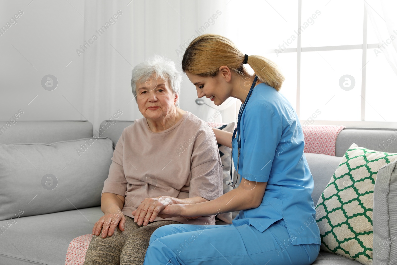 Photo of Nurse with elderly woman indoors. Assisting senior people