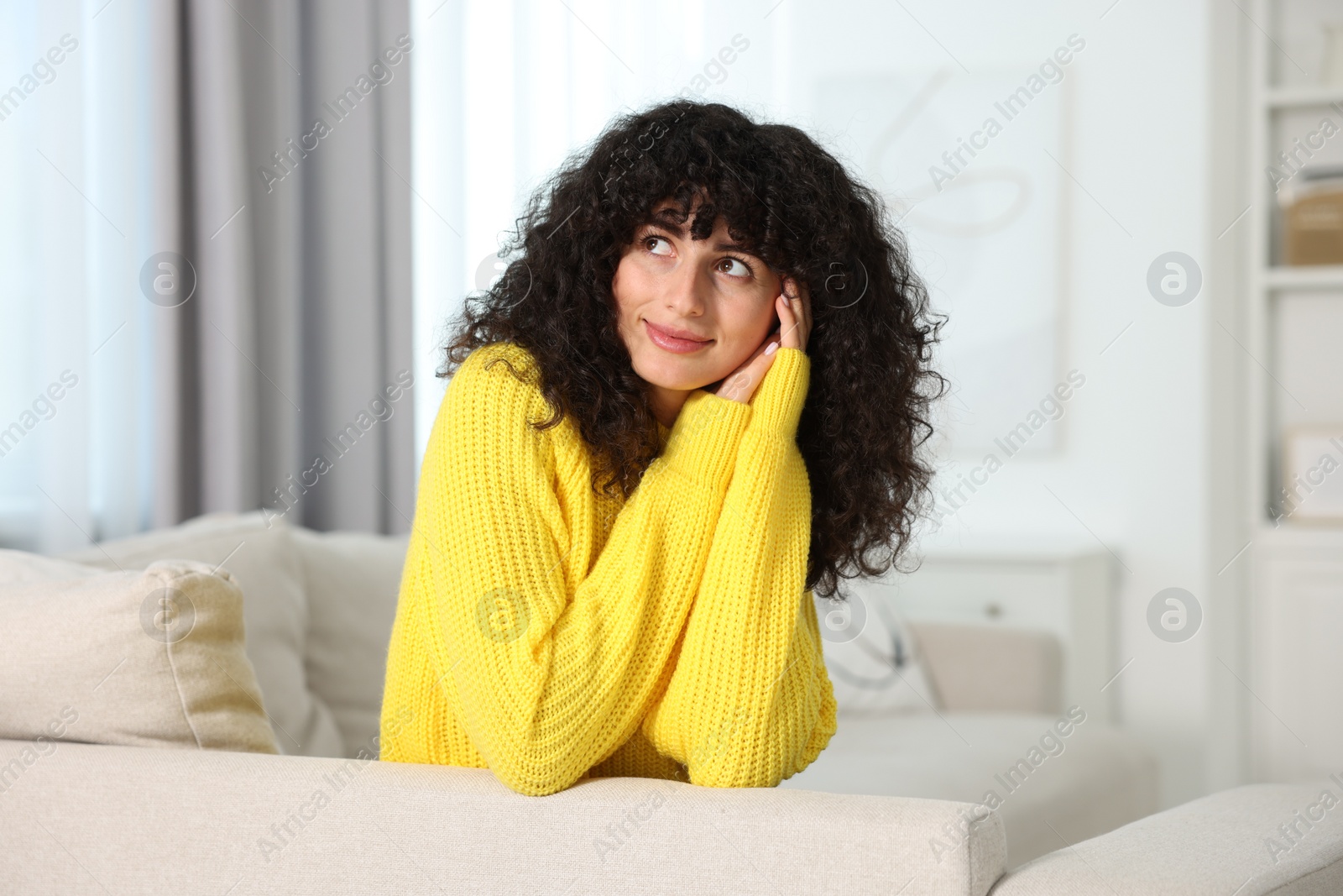 Photo of Young woman in stylish yellow sweater indoors