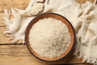 Photo of Raw basmati rice on wooden table. flat lay