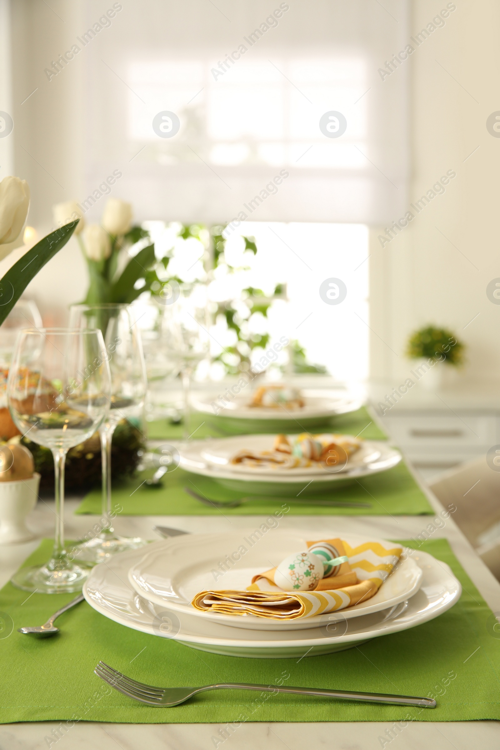 Photo of Festive Easter table setting with floral decor in kitchen