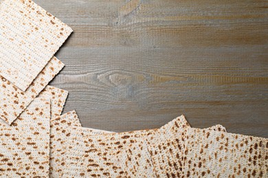 Photo of Traditional matzos on wooden table, flat lay. Space for text