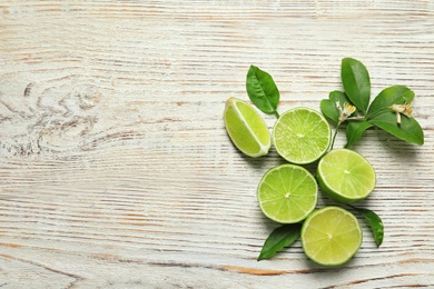 Composition with fresh ripe limes on wooden background, top view