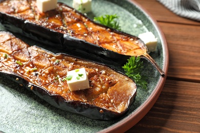 Plate with fried eggplant slices on wooden table, closeup