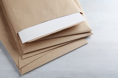 Photo of Stack of big kraft paper envelopes on light table, closeup