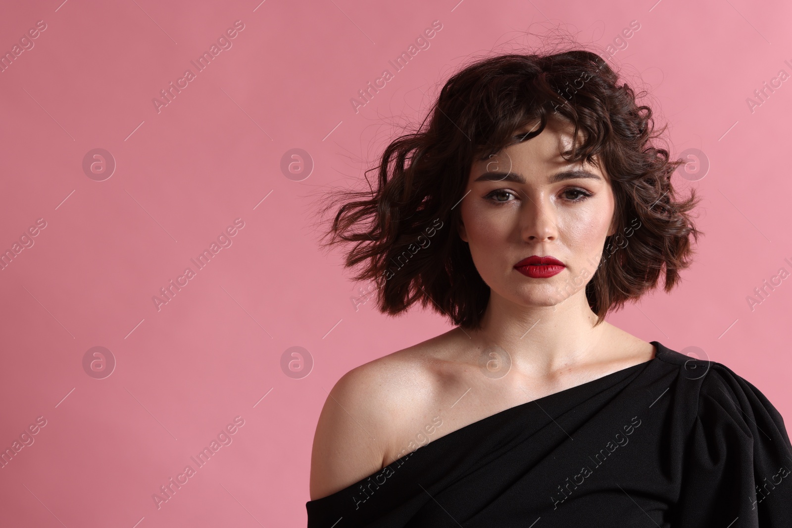 Photo of Portrait of beautiful young woman with wavy hairstyle on pink background. Space for text