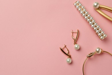 Photo of Elegant hair clips, bracelet and earrings with pearls on pink background, flat lay. Space for text