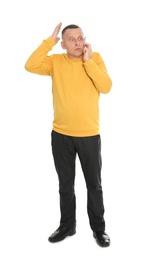 Full length portrait of emotional mature man talking on phone against white background