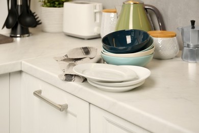 Photo of Set of clean color bowls and plates on white countertop in kitchen
