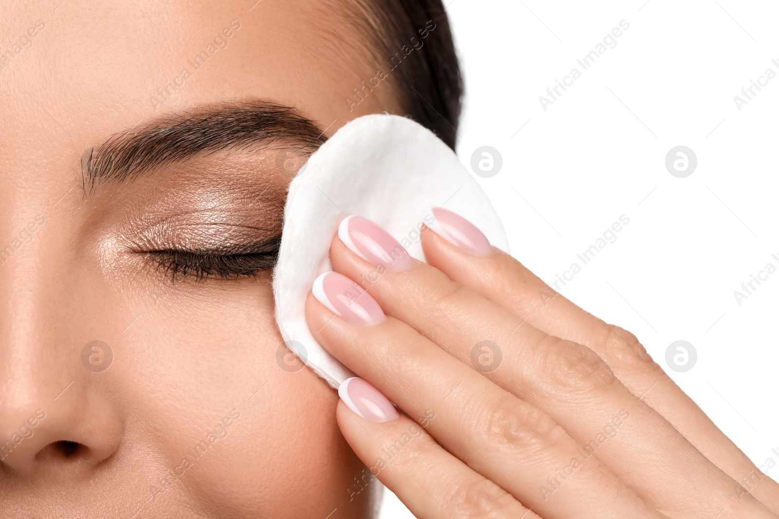 Photo of Beautiful woman removing makeup with cotton pad on white background, closeup