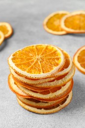 Dry orange slices on light grey table, closeup