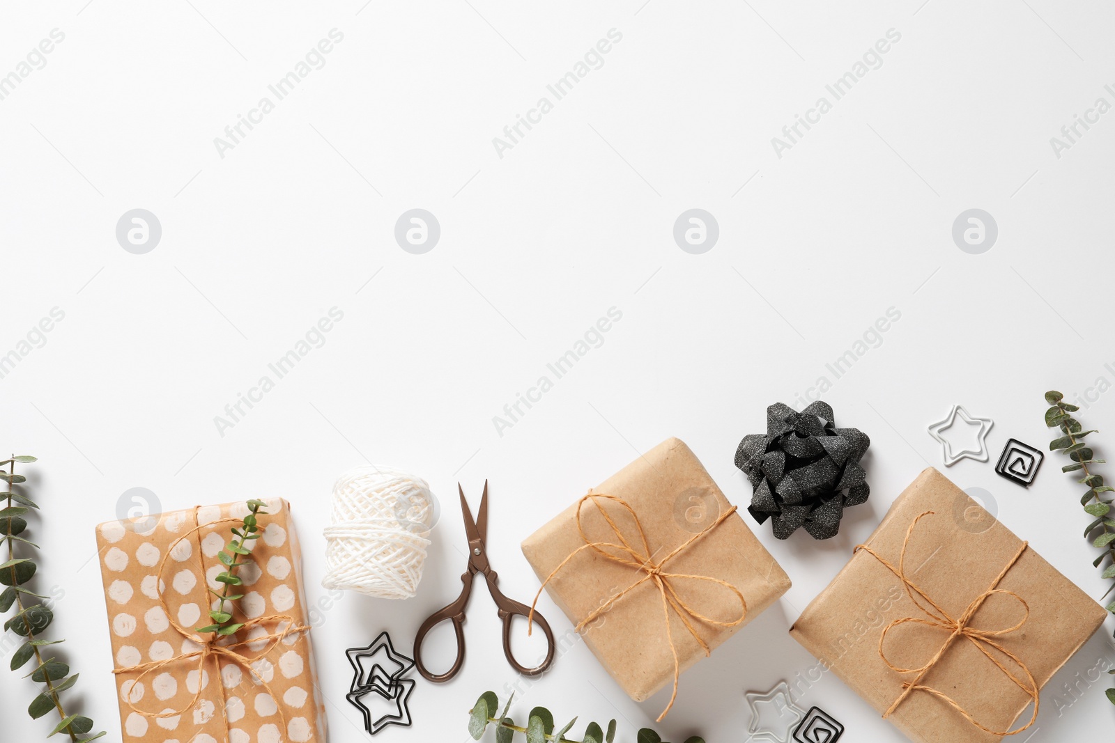 Photo of Composition of scissors and gifts on white background, top view