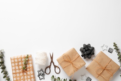 Composition of scissors and gifts on white background, top view