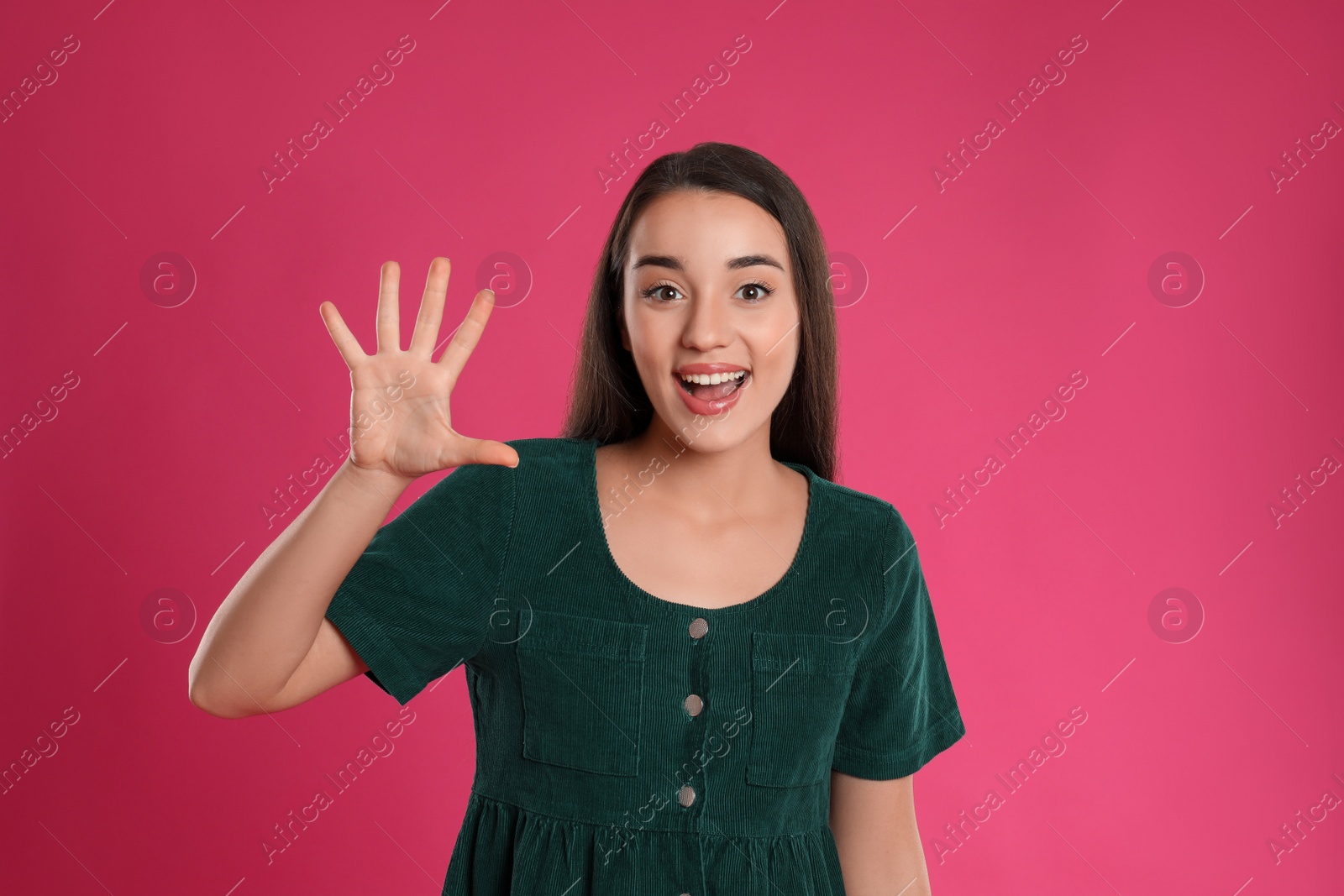 Photo of Woman showing number five with her hand on pink background