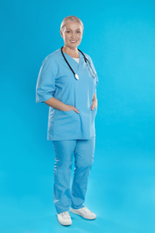 Photo of Portrait of mature doctor with stethoscope on blue background