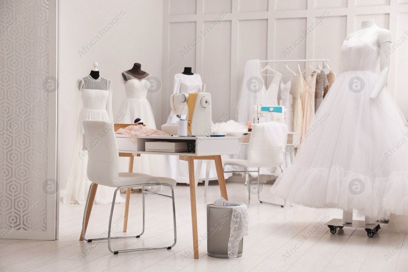 Photo of Dressmaking workshop interior with wedding dresses and equipment