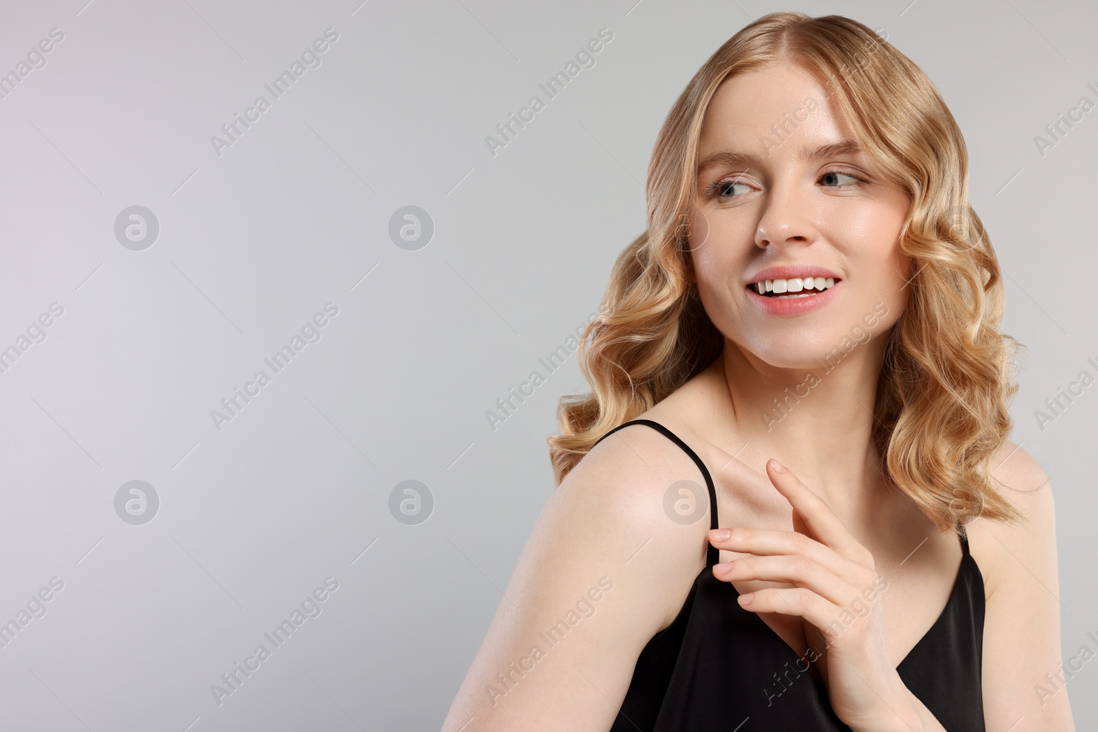 Photo of Portrait of beautiful woman with blonde hair on light grey background. Space for text