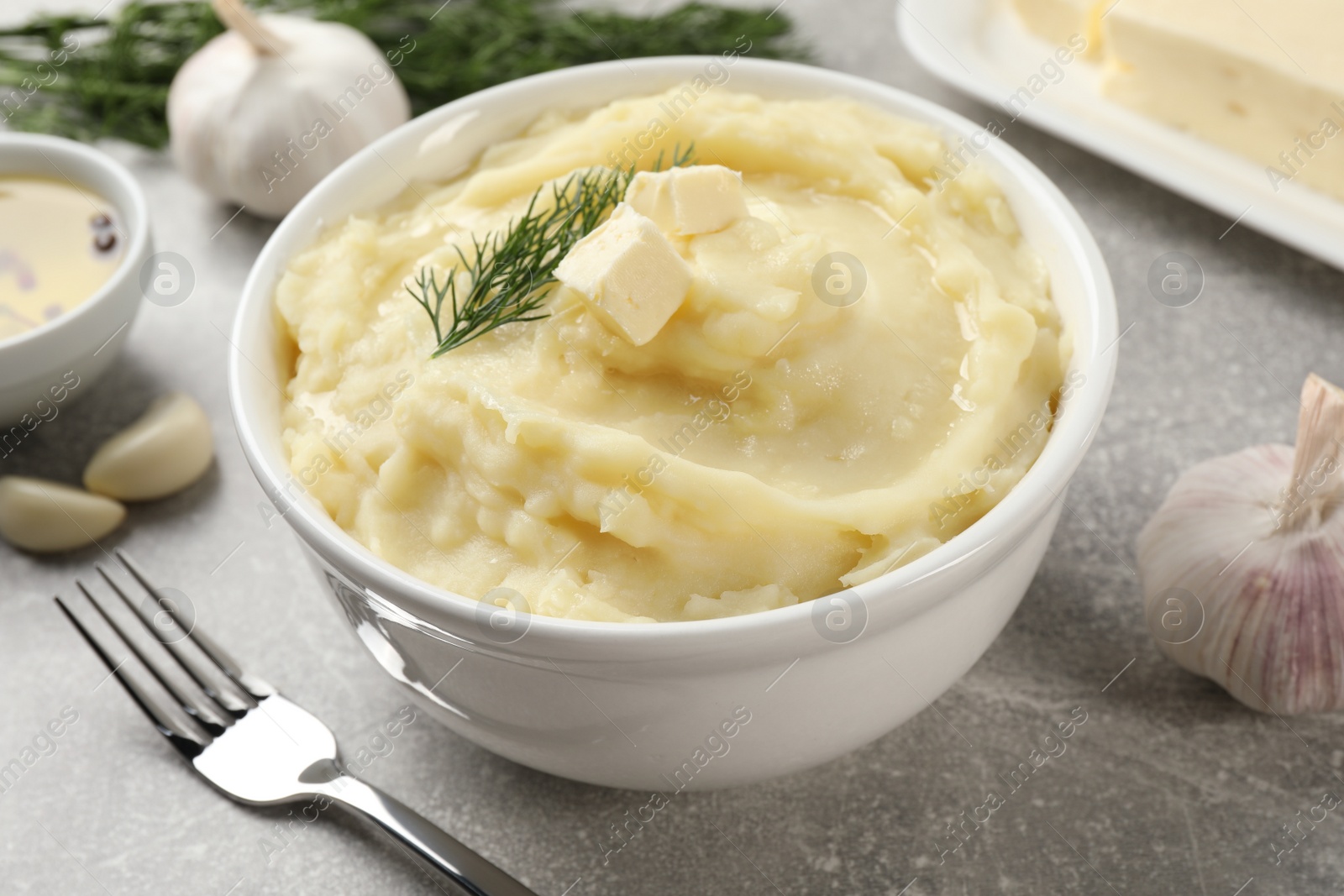 Photo of Delicious mashed potato with dill served on light grey table