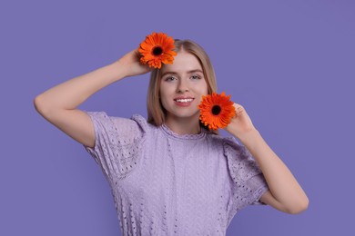 Photo of Beautiful woman with spring flowers in hands on purple background