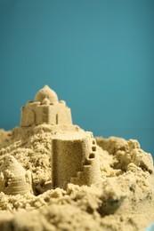 Photo of Pile of sand with beautiful castle on light blue background. Space for text